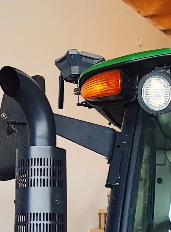 precision agriculture technology: a close up of a tractor headlight with Reach GNSS receiver